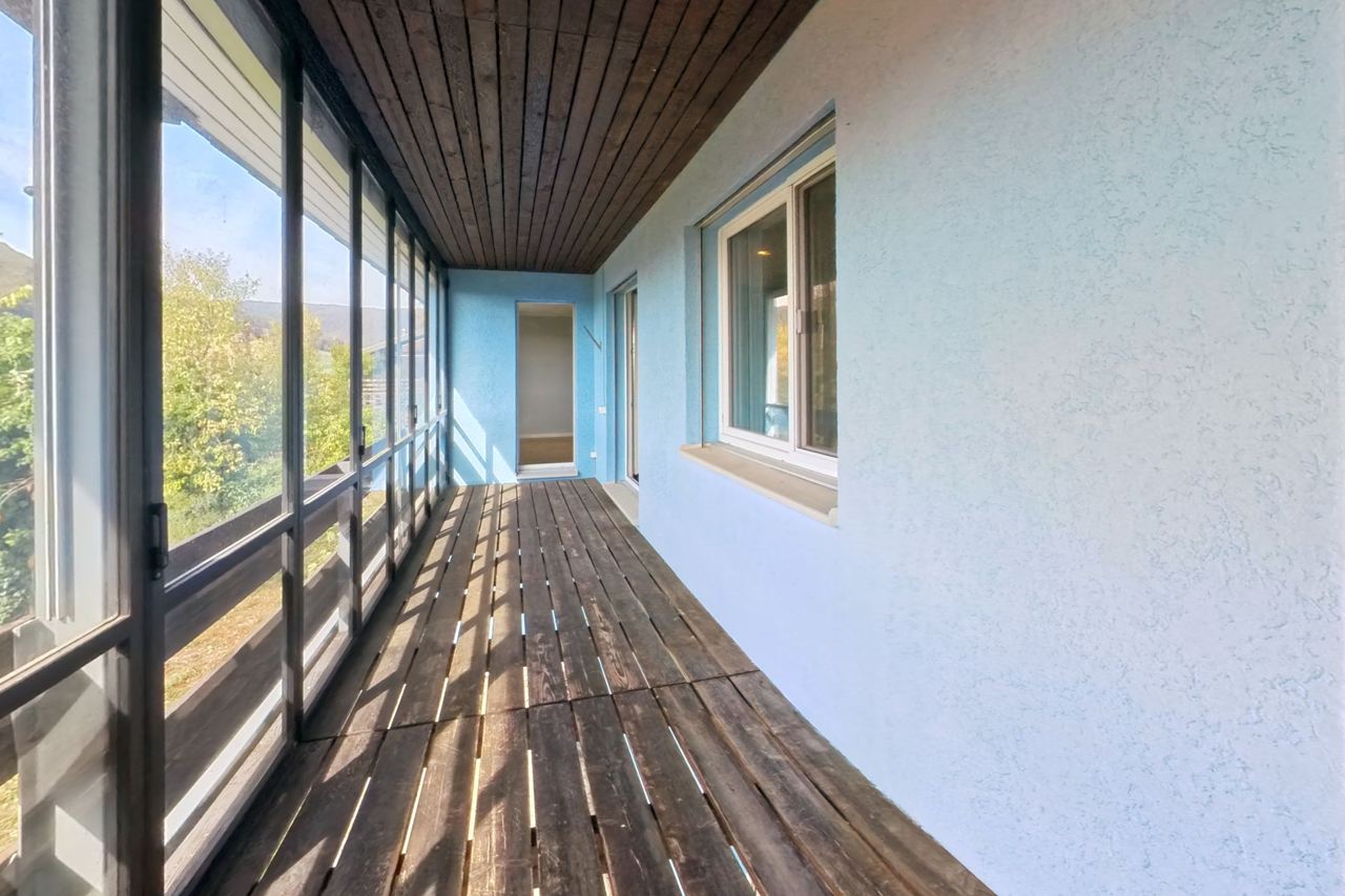 Gedeckter Balkon mit Holzdecke, Holzrost und Blick ins Grüne